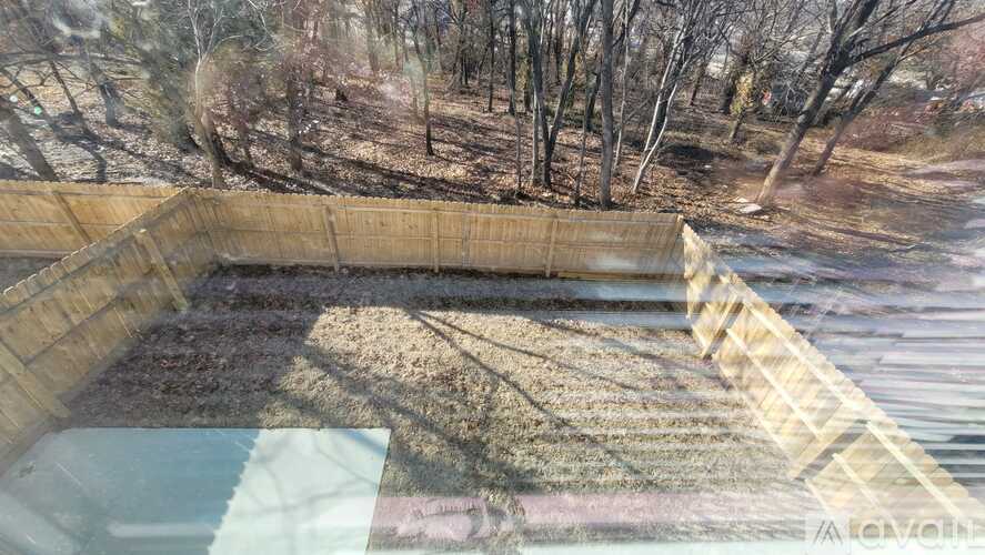 A pool surrounded by a wooden fence with trees in the background.