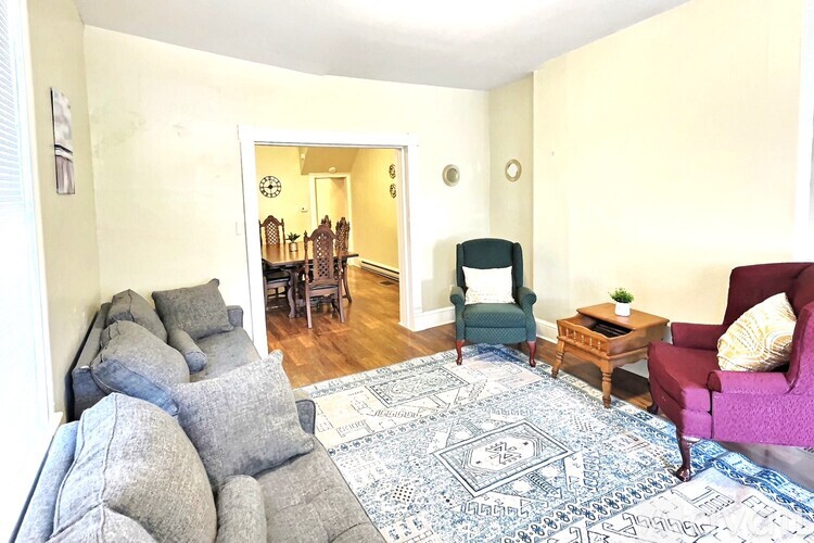 A living room with a grey couch and a patterned rug.