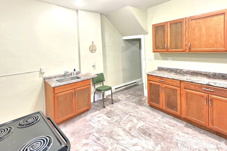 A kitchen with wooden cabinets and a black stove top.