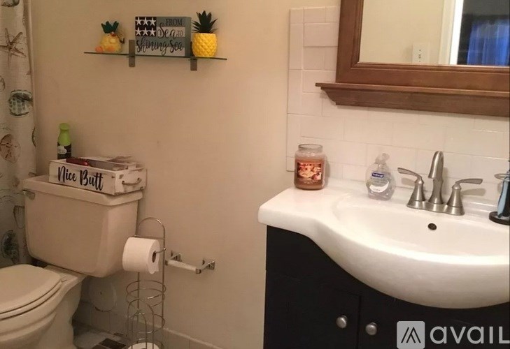 A bathroom with a toilet, sink, and a mirror.