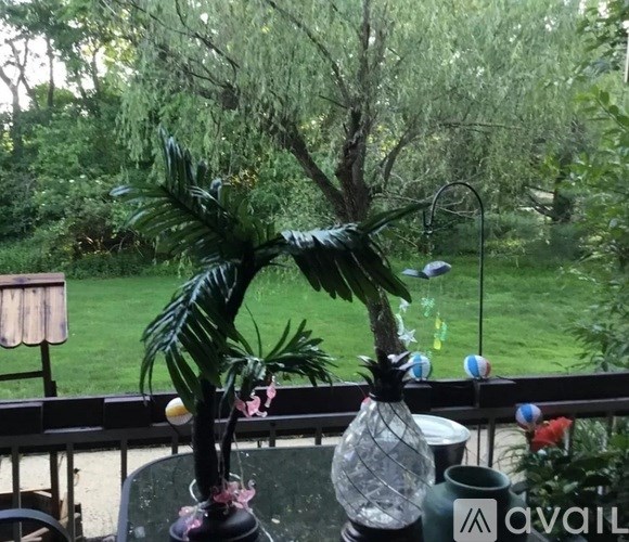 A potted plant sits on a table with a glass vase and a metal stand.