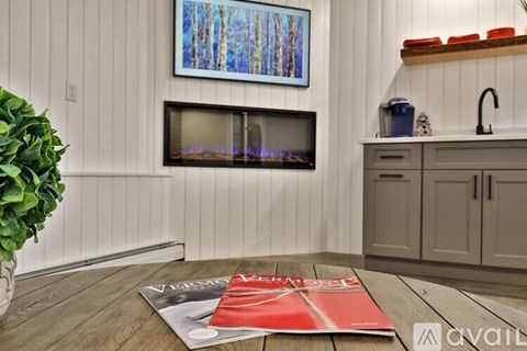 A living room with a fireplace and a painting on the wall.