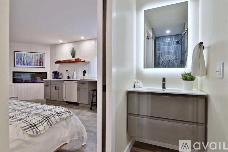 A bedroom with a bed and a vanity with a mirror.