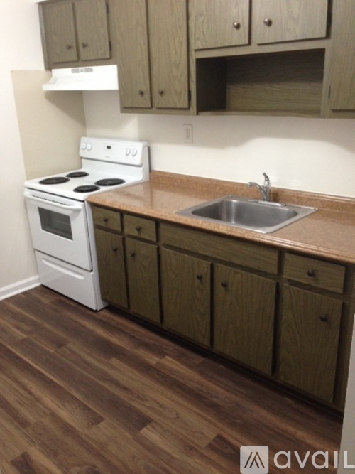 A kitchen with a white stove and wooden cabinets.