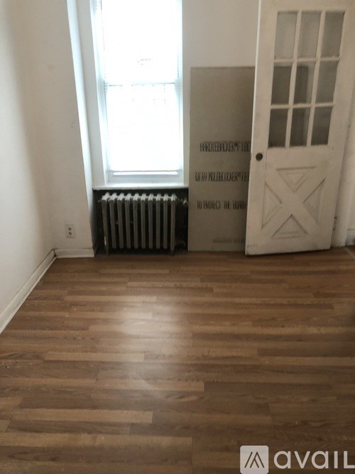 A room with wooden floors and a white door.