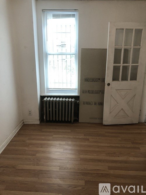 A room with a white door and a window with blinds.