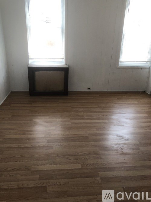 A room with wooden flooring and a window.