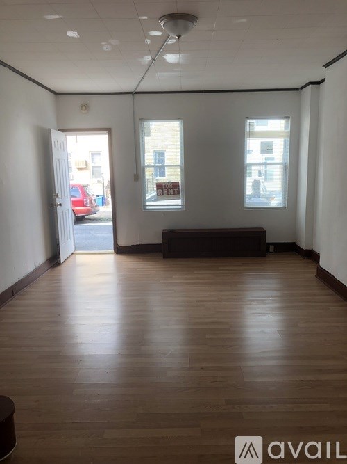 A room with wooden floors and a large window.