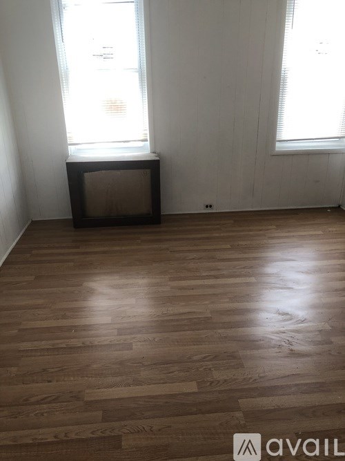 A room with wooden flooring and a window.