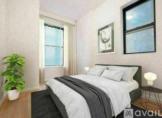 A bedroom with a bed, a potted plant, and a window.