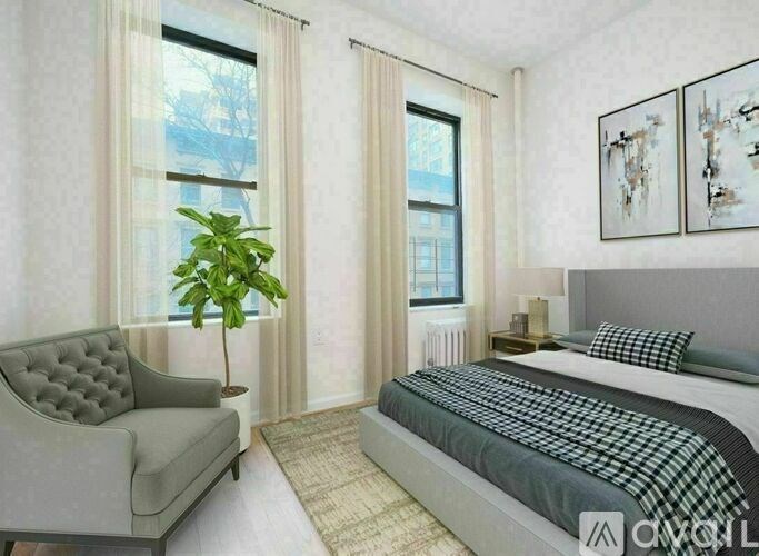 A bedroom with a bed, a chair, and a potted plant.