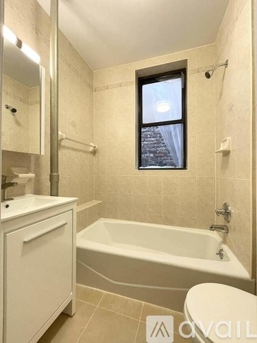 A bathroom with a tub, toilet, and sink.