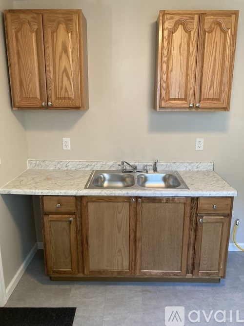 A kitchen with wooden cabinets and a marble countertop.