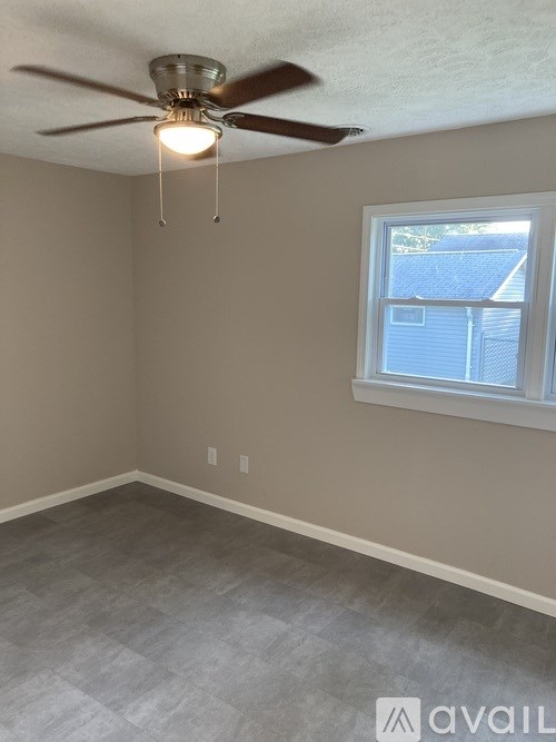 A room with a ceiling fan and a window.
