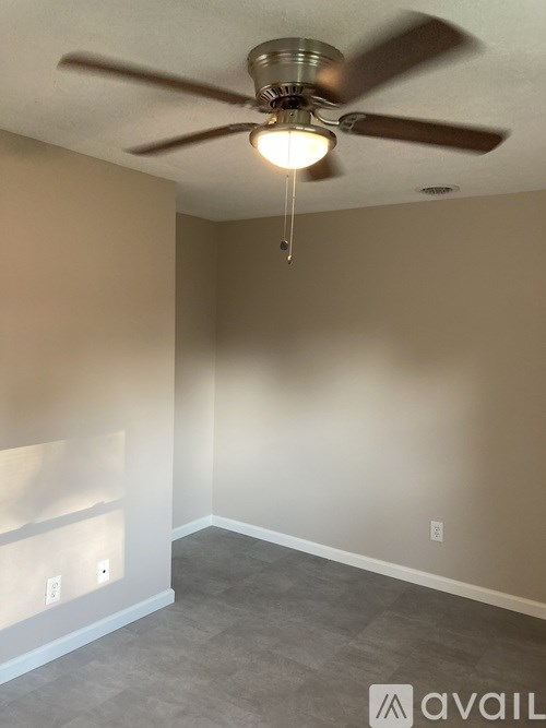 A room with a ceiling fan and light fixture.