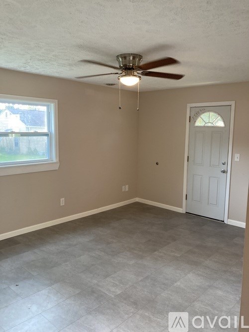 A room with a ceiling fan and a door.