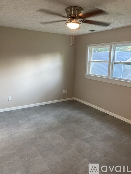 A room with a ceiling fan and a window.