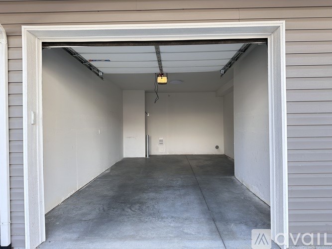 A garage with a white door is empty and has a concrete floor.
