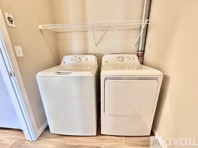 A white washing machine and dryer in a laundry room.