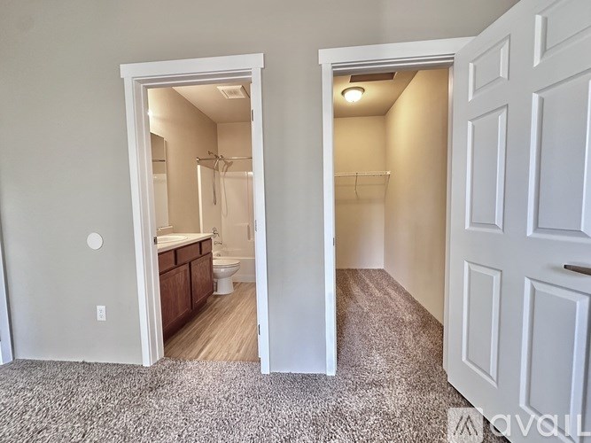A bathroom with a toilet, sink, and a shower is visible through an open door.