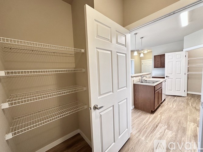 A kitchen with a white door and shelves.