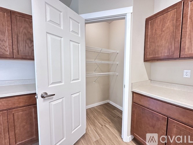 A kitchen with a white door and brown cabinets.
