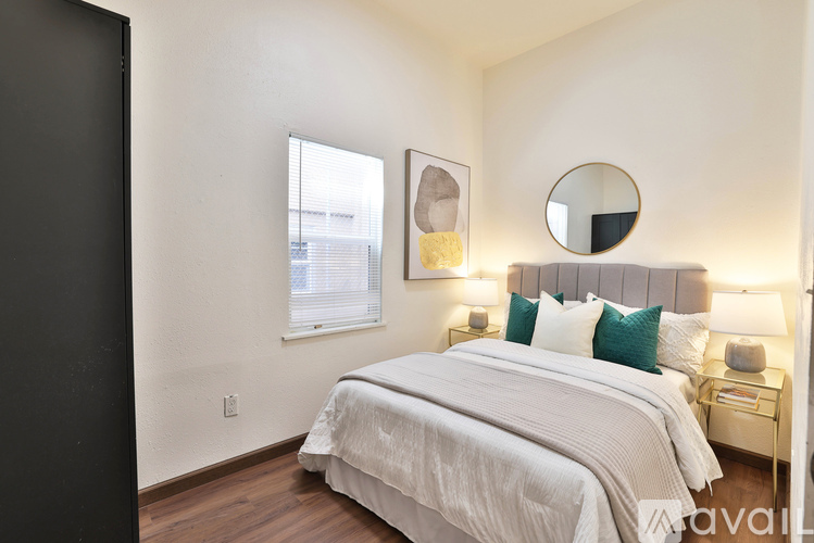 A bedroom with a large bed and a mirror above it.