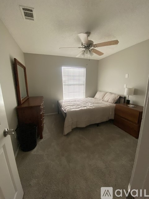 A bedroom with a bed, dresser, and mirror.