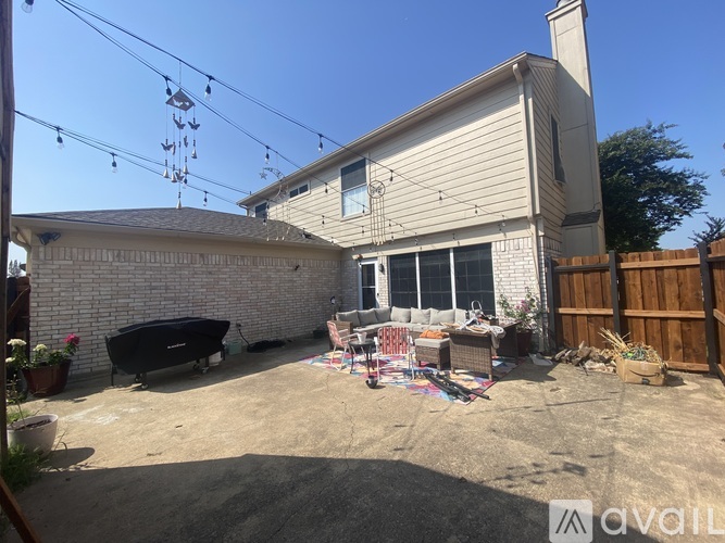 A backyard with a hot tub, patio furniture, and a wooden fence.