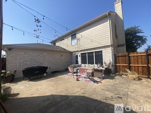 A backyard with a hot tub, patio furniture, and a wooden fence.