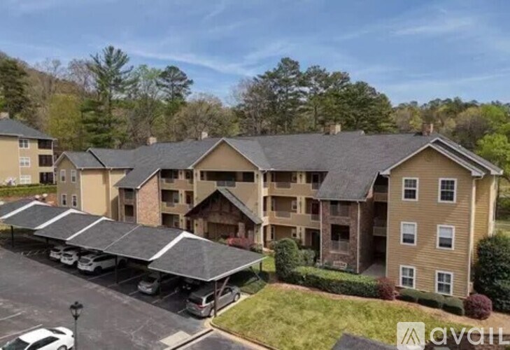 A large apartment complex with a parking lot in front.