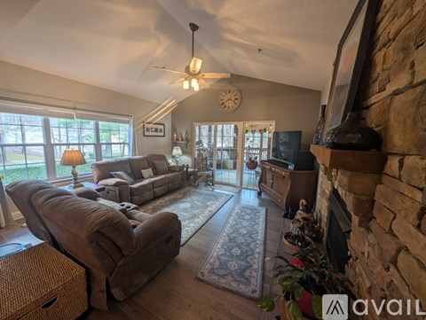 A living room with a brown couch and a fireplace.