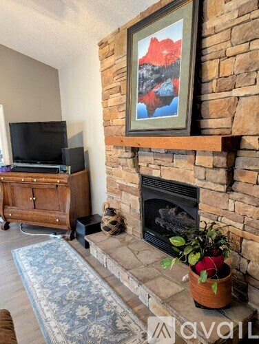 A living room with a fireplace and a painting on the wall.