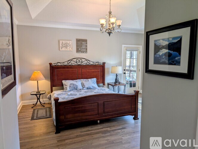 A bedroom with a large bed and a chandelier.