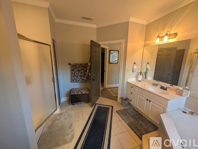 A bathroom with a white vanity and a black and white rug.