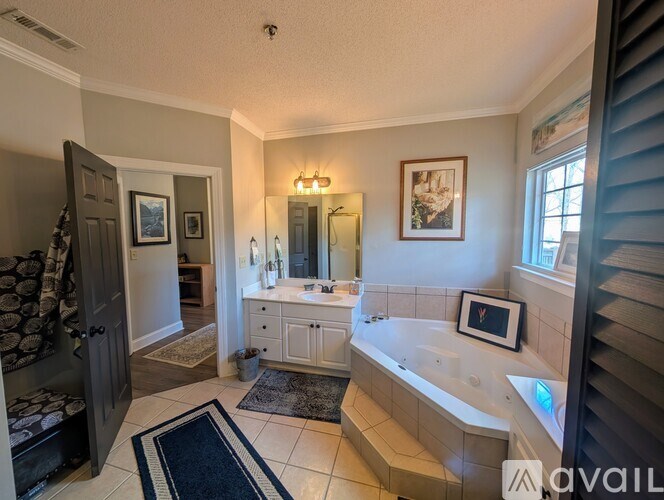 A bathroom with a tub, sink, and mirror.