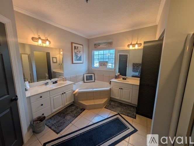 A bathroom with a tub, sink, and mirror.