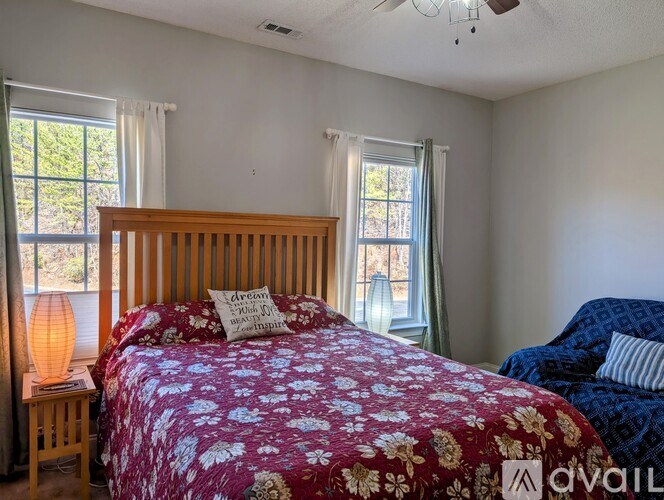 A bedroom with a red floral bedspread and a blue patterned bed in the background.