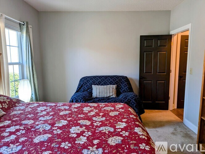 A bedroom with a red floral bedspread and a blue patterned bed.