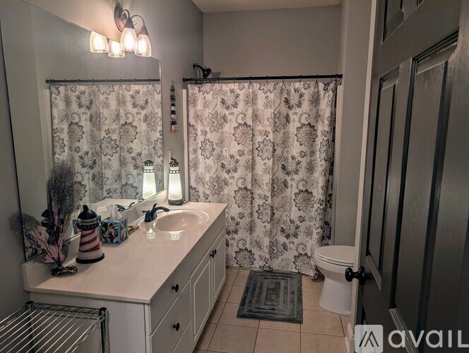 A bathroom with a sink, toilet, and shower curtain.