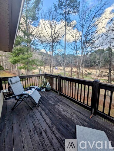 A wooden deck with a chair and a table is shown.
