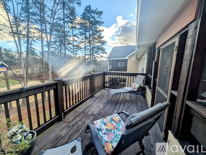A sunny day on a wooden deck with a chair and table.