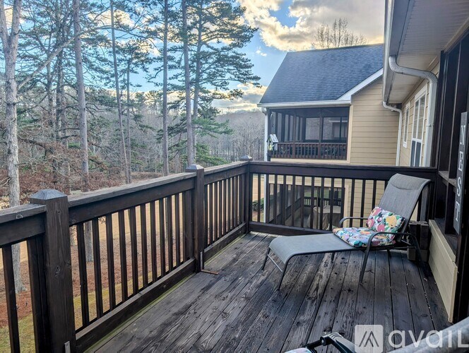 A wooden deck with a chair and a table is shown.