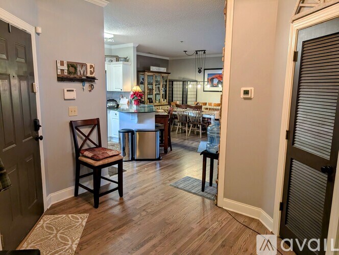 A kitchen with a wooden floor and a dining table with chairs.