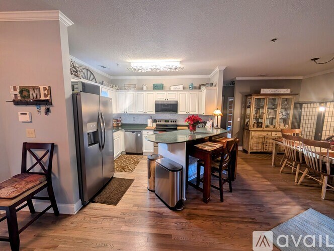 A kitchen with a refrigerator, a dining table with chairs, and a washing machine.