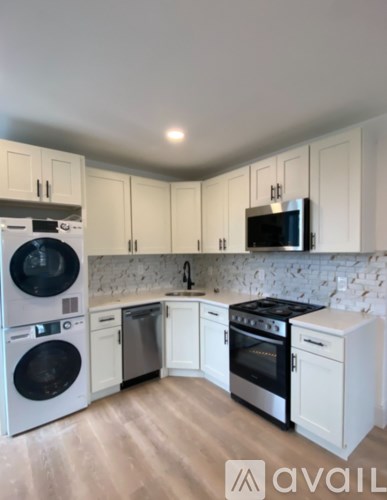 A kitchen with white cabinets and appliances.