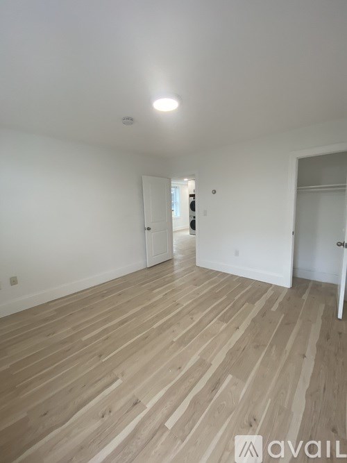A room with wooden flooring and white walls.