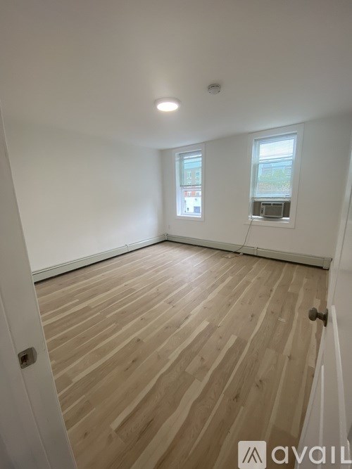 A room with wooden flooring and a window.