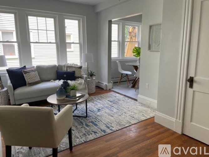 A living room with a white couch, a coffee table, and a rug.