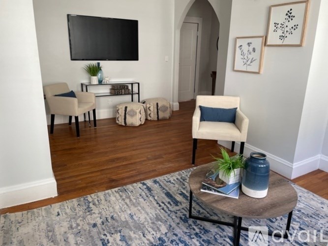 A living room with a flat screen TV mounted on the wall.